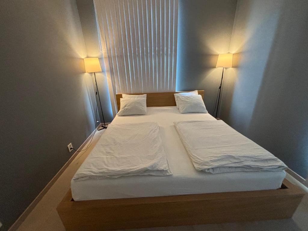 a bedroom with a bed with two lamps on it at Apartment in Central Røa Oslo by the Train Station in Oslo