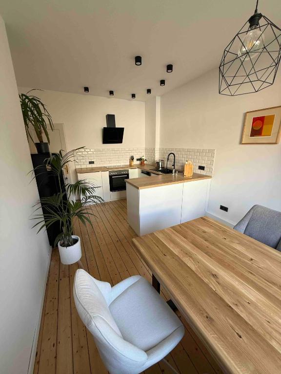 eine Küche mit einem Holztisch und einer weißen Küchenzeile in der Unterkunft Moderne Wohnung mit Garten - Top Lage im schönen Mauritzviertel in Münster