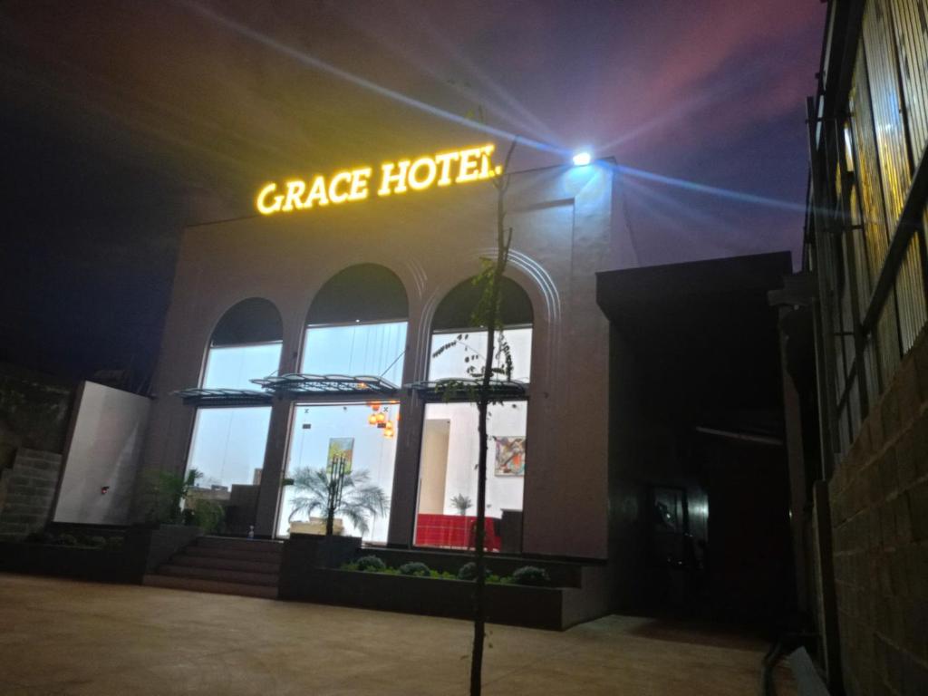a garage hotel with a neon sign in front of it at Grace hotel - dakmil in Bon Sar Pa