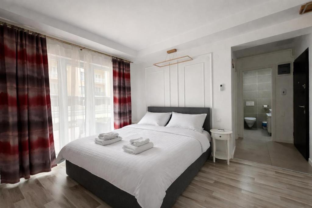 a bedroom with a large bed with two towels on it at Nori Studio #Garden&Pool in Ştefăneştii de Sus