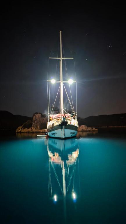 a sail boat sitting in the water at night at Cakabey Yachting in Demre