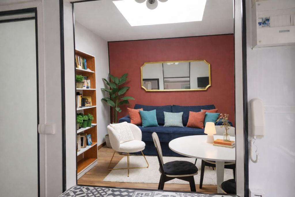 a living room with a blue couch and a table at Maison cosy citadine in Tours