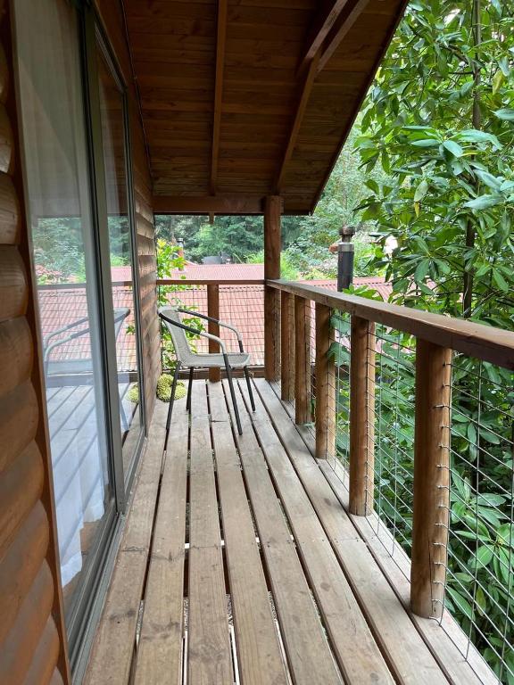 eine hölzerne Veranda mit einer darauf stehenden Bank in der Unterkunft cabañas arca in Pucón