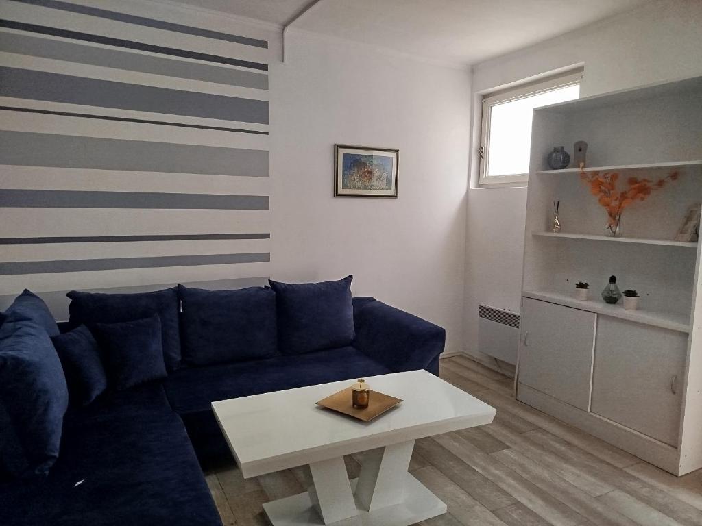 a living room with a blue couch and a table at Mejdan II in Mostar