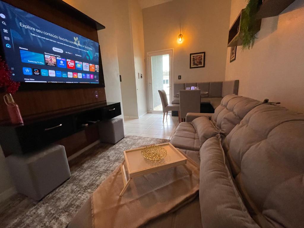 a living room with a large couch and a flat screen tv at Aeroporto Manaus in Manaus