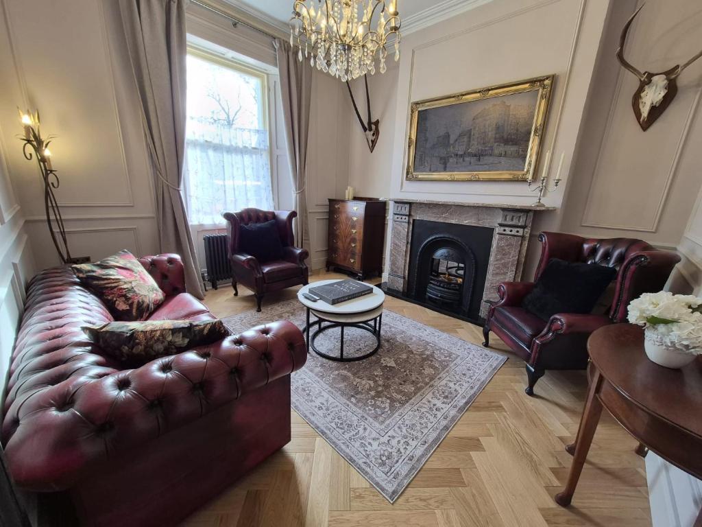 a living room with a leather couch and a fireplace at NO 60 Sligo in Sligo