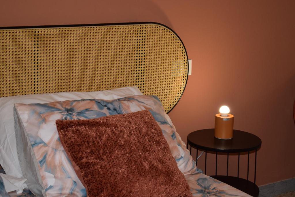 a candle sitting on a table next to a bed at La casetta di Leo in Poggibonsi