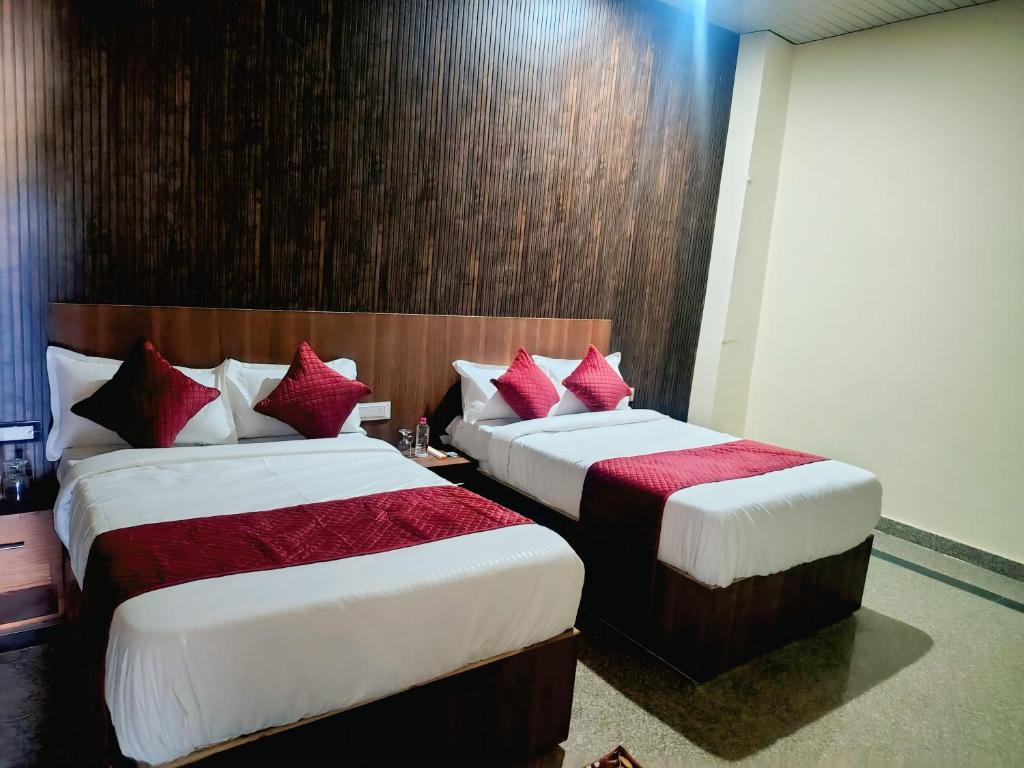 two beds in a hotel room with red pillows at Hotel Udaan Stay in Jaipur