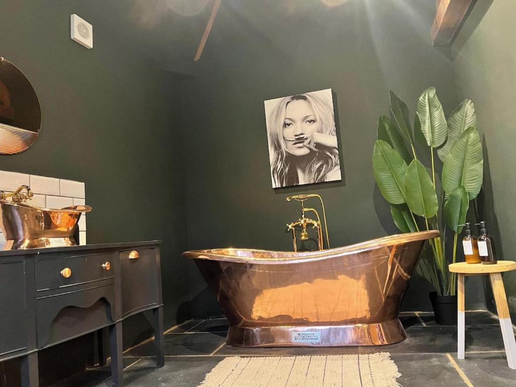 a bathroom with a copper tub and a picture of a woman at Torworth - 1 Bed Barn - Sleeps 3 - Hot Tub in Torworth
