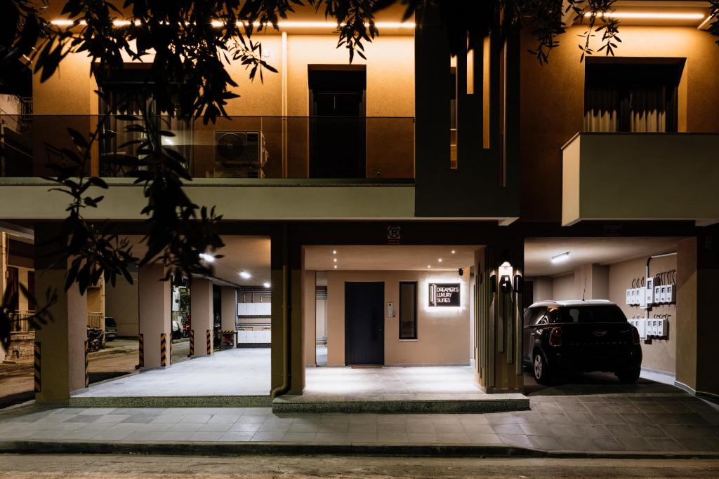 a building with a car parked in a parking lot at Dreamer's Luxury Suites in Volos