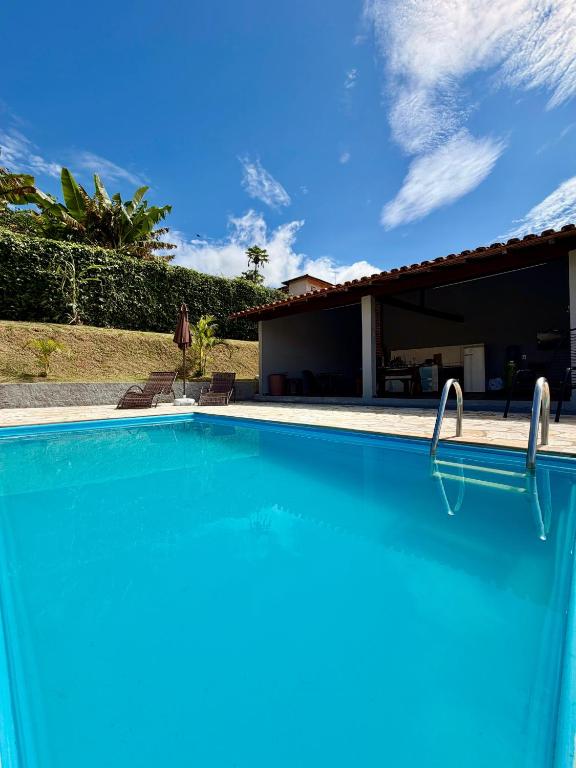 a swimming pool in front of a house at Chacara Souza in Socorro