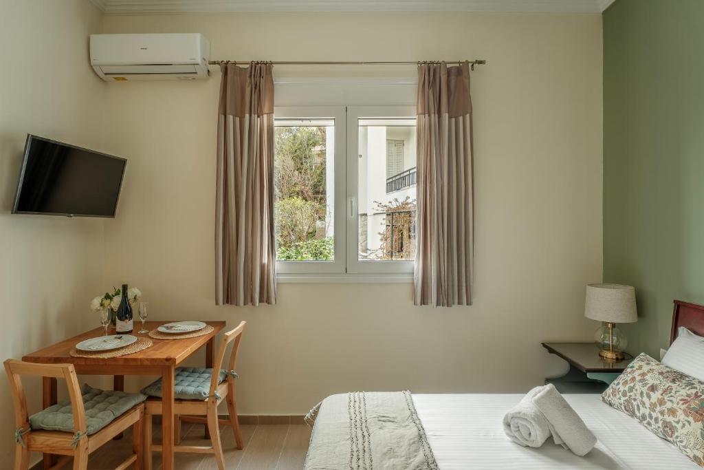 a bedroom with a table and a bed and a window at AROI Studio in Patra