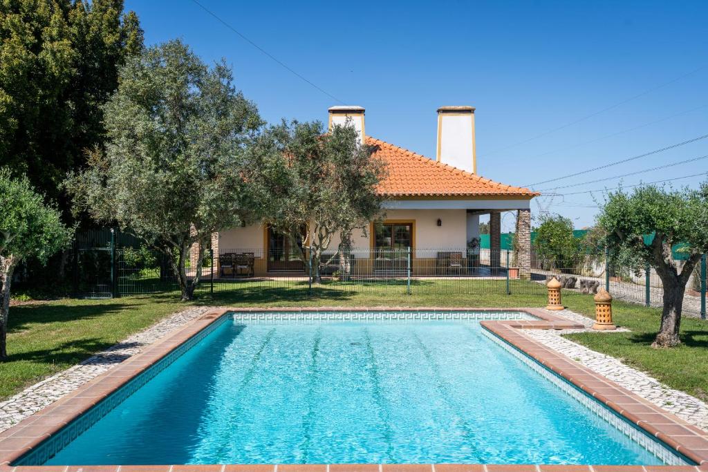 a swimming pool in front of a house at Casa com Piscina Privada em Palmela - Jardim & Estacionamento in Palmela