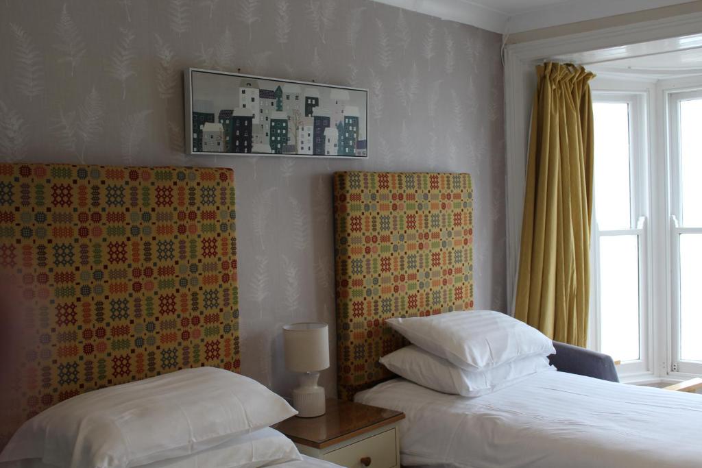 a bedroom with two beds and a window at Cranwell Court in Aberystwyth