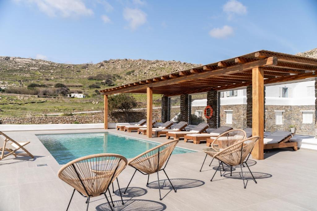 a patio with chairs and a swimming pool at Hillside Collection - by Hospirit in Mikonos