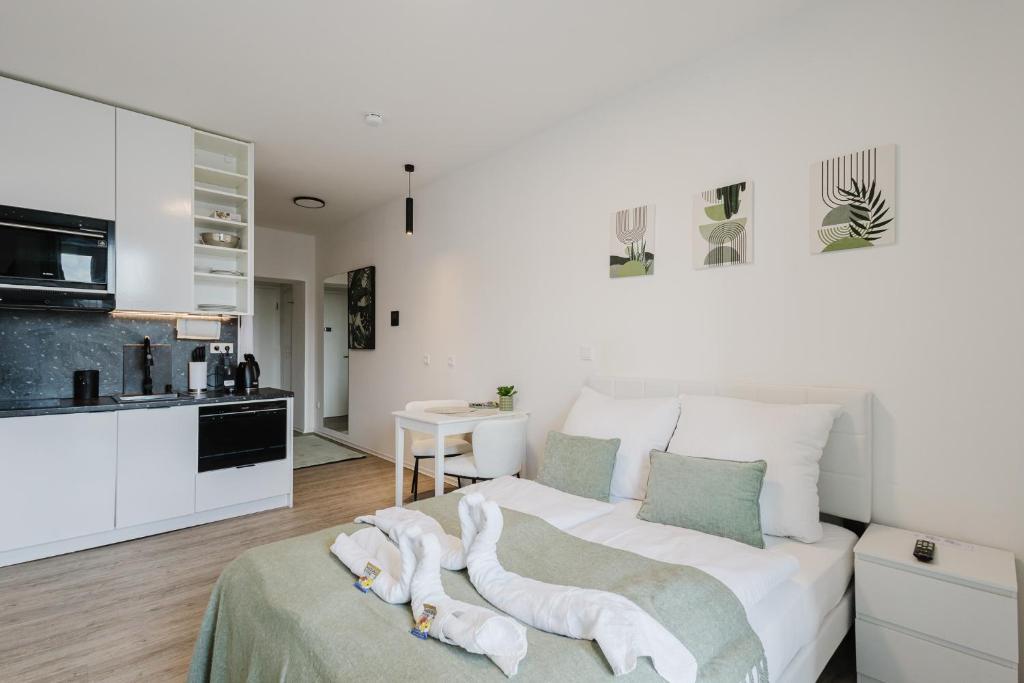 a white bedroom with a bed with towels on it at Design-Studio mit Balkon - Nähe Donau in Passau