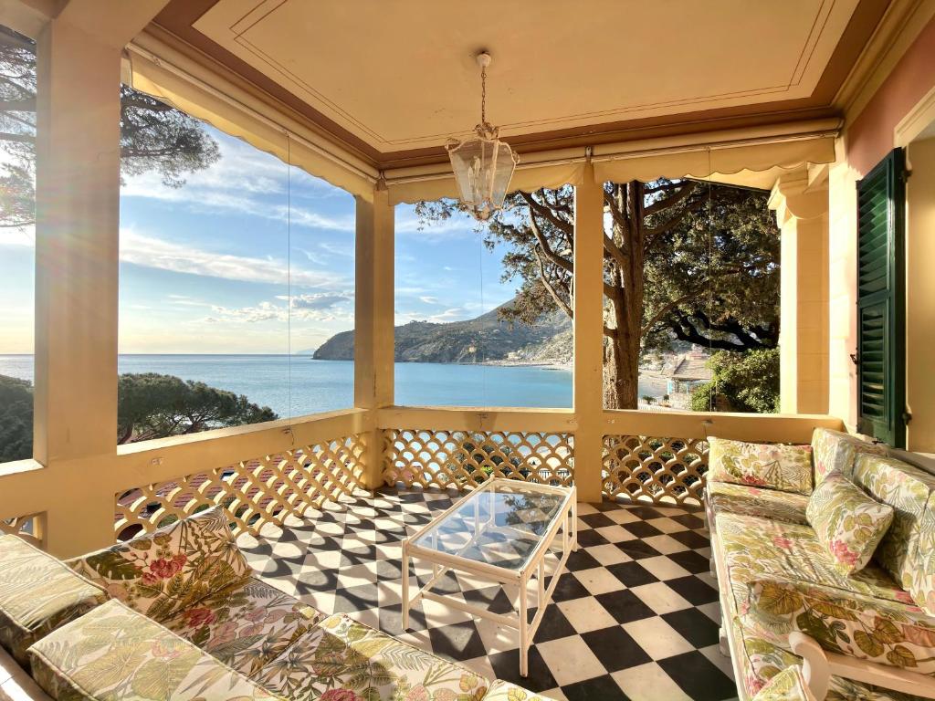 a screened in porch with couches and a table at VILLA NORMA in Levanto