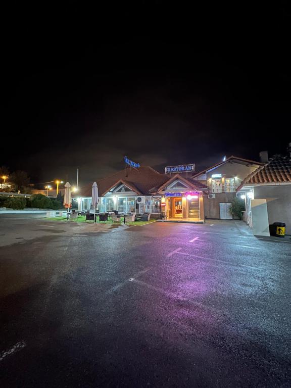 a parking lot in front of a hotel at night at Motel Era i Sin in Ba°evac