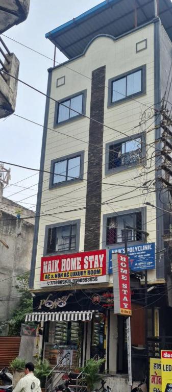 a tall building with ahak home stay sign in front of it at Naik Homestay in Indore