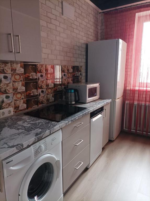 a kitchen with a refrigerator and a washing machine at Apartment Danchehko 3b in Chornomorsk