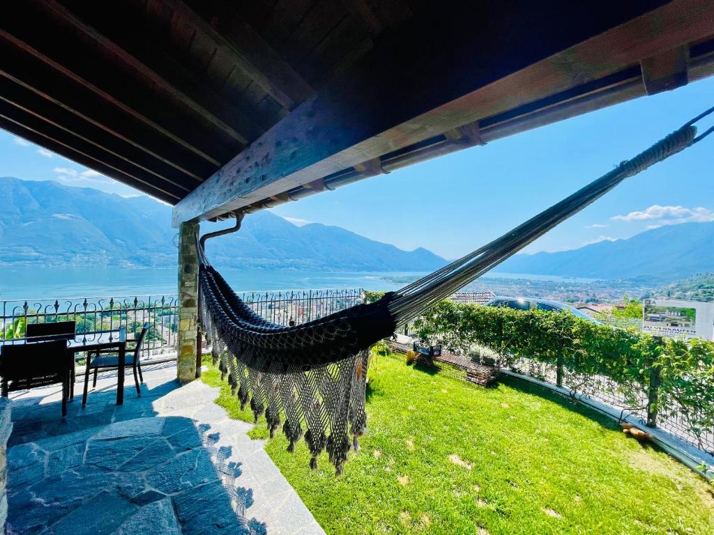 a hammock on the roof of a house with a view at Charmantes Rustico La Vedetta mit Terrasse in Minusio