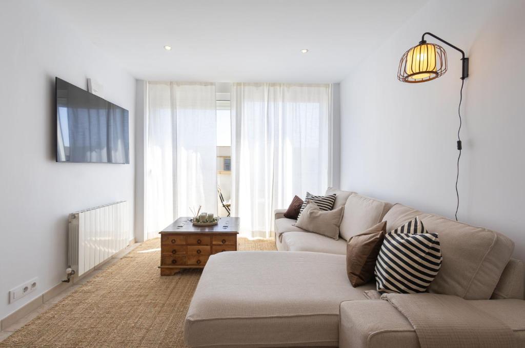 a white living room with a couch and a table at L’Ancora Suite in Jávea