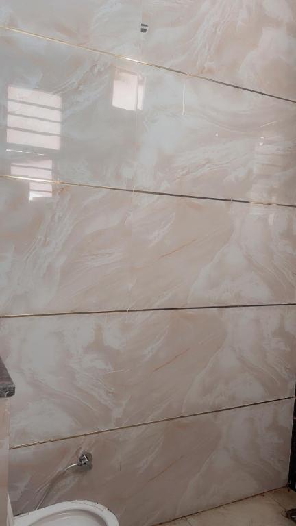 a bathroom with a white wall next to a toilet at House in Mohali
