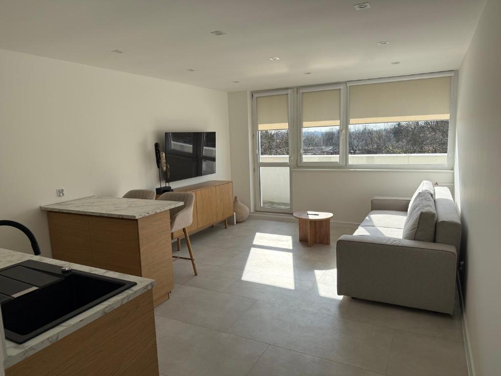 a living room with a couch and a table at CentralPark Katowice in Katowice