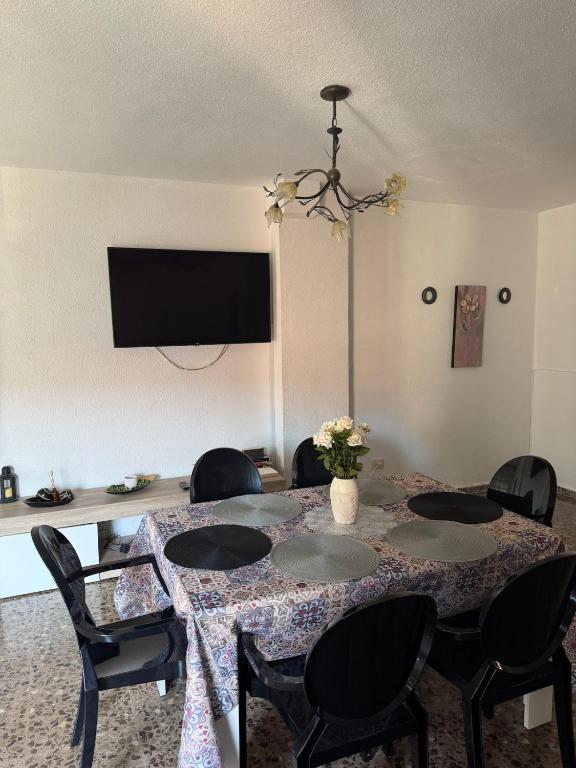 a room with a table with chairs and a tv at Apartamento Dúplex vacacional in Burriana