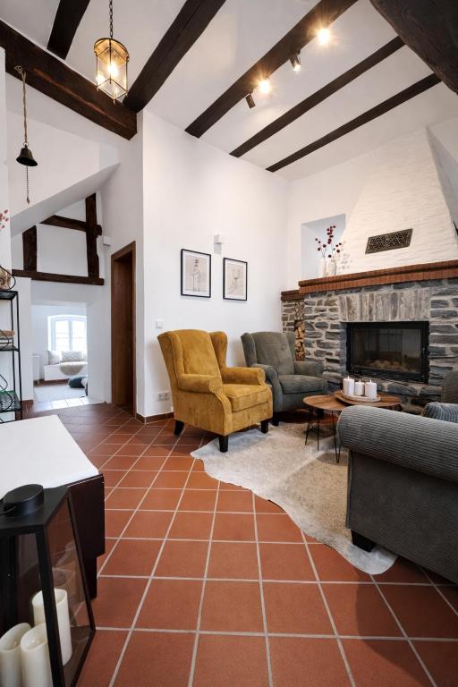 a living room with couches and a fireplace at Zur Klapperburg in Zell an der Mosel