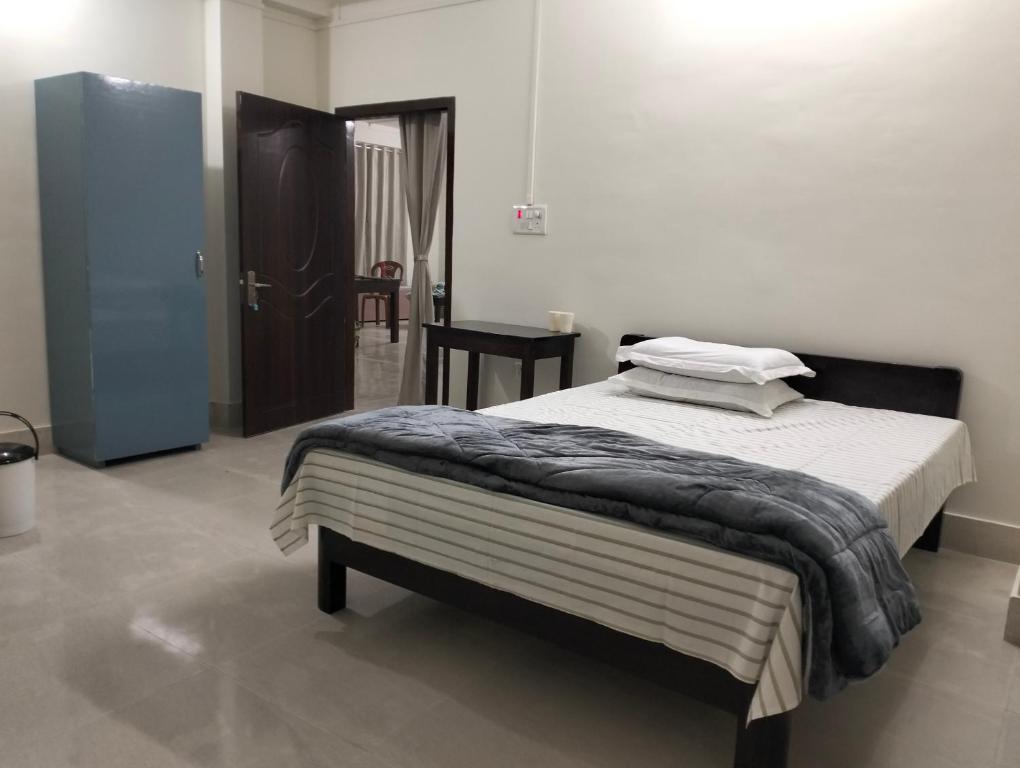 a bedroom with a bed and a table in it at Windfall Homestay in Dimapur