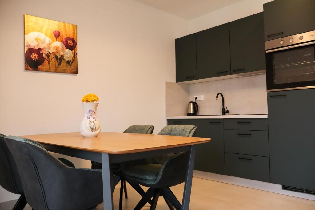 a kitchen with a table with chairs and a vase on it at Velebit Escape Apartments in Starigrad