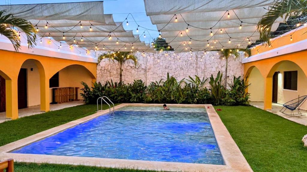 a pool in a yard with a person in the water at Hotel Villa Chucum in Valladolid