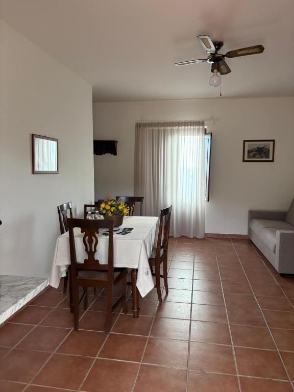 a dining room with a table and chairs and a couch at La Dimora del Molo in Fuscaldo