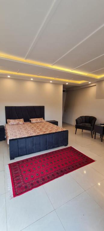 a bedroom with a bed and a red rug at Abbott royale farm in Abbottabad
