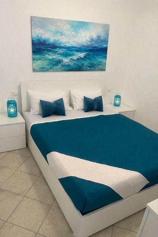 a bedroom with a bed with blue and white pillows at perla house in Valledoria