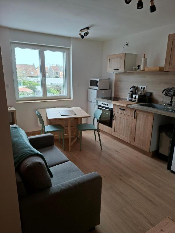 a kitchen with a couch and a table in a room at nid doré in Calais