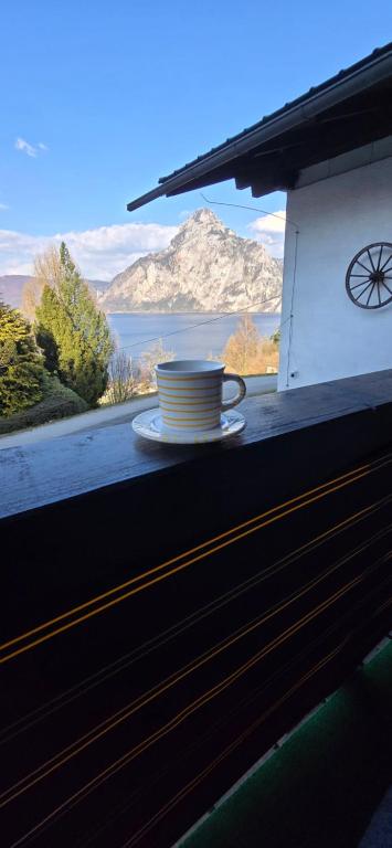 a cup and a plate sitting on a window sill at Ferienwohnung-Edna-Traunkirchen in Traunkirchen