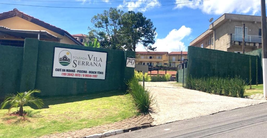 a sign on a fence in front of a building at Pousada Vila Serrana in Serra Negra
