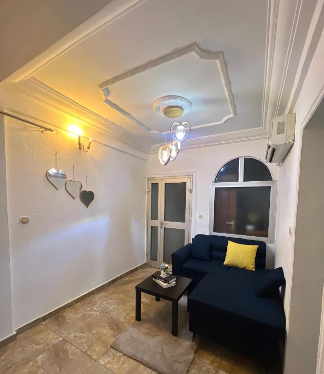 a living room with a blue couch and a table at Studio meublé akwa in Douala