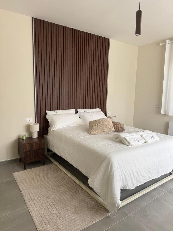 a bedroom with a large bed with white sheets at Villa Perla in Battipaglia