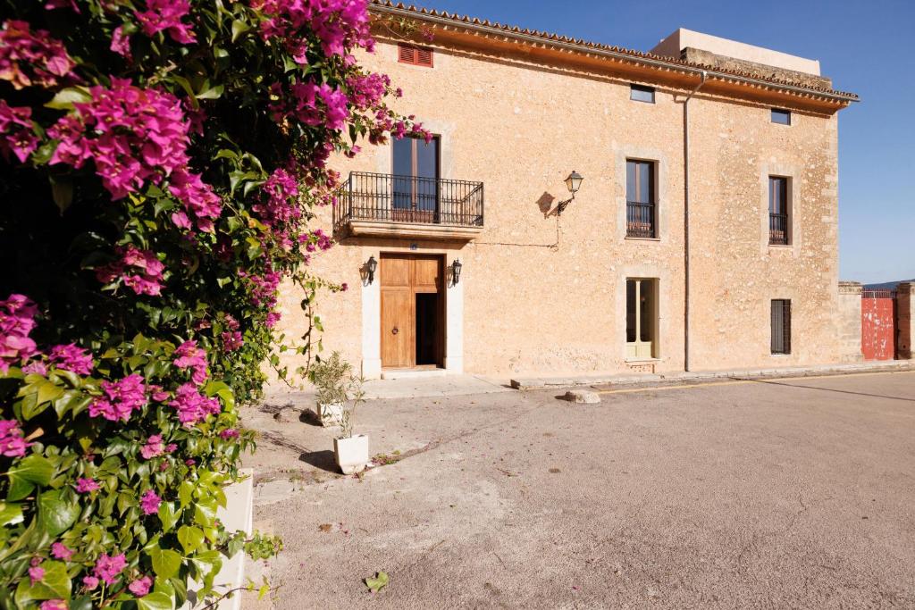 a building with pink flowers in front of it at Mansión Santa María in Santa Maria del Camí