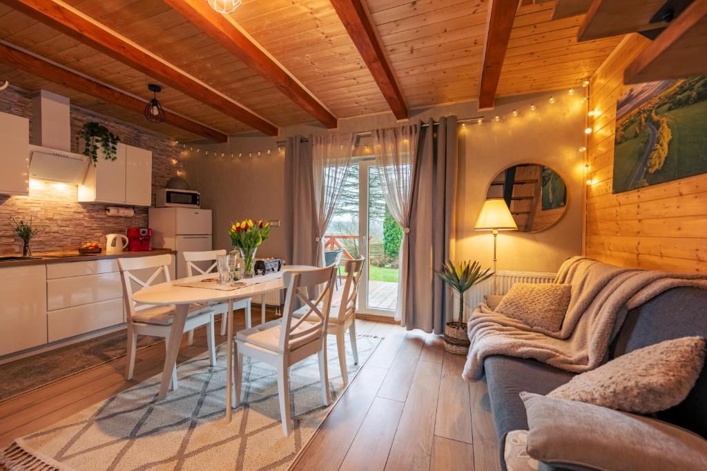 a kitchen and living room with a table and a couch at Osada u Beatki - Strefa SPA in Lutowiska