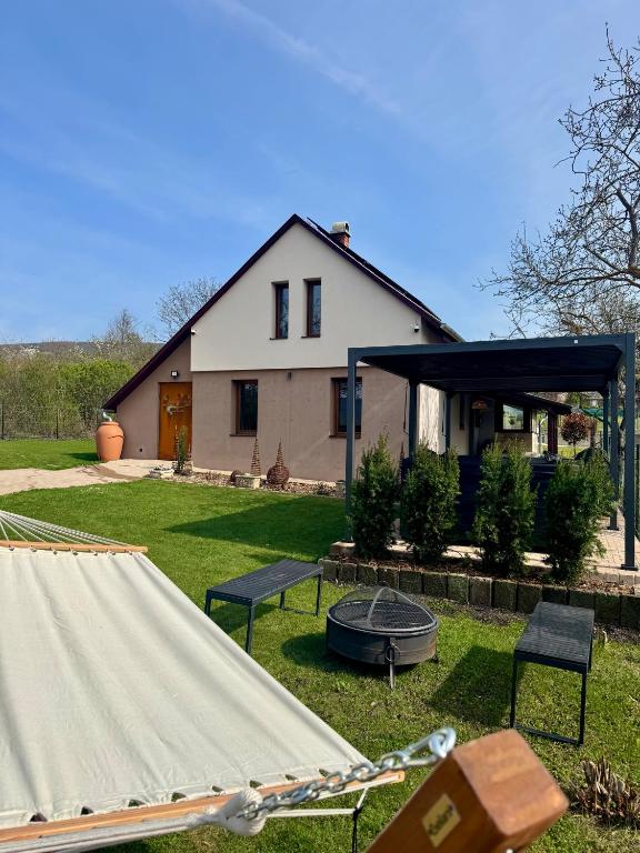 a house with a tent and a fire pit in the yard at Öregvíz Vendégház in Szentendre