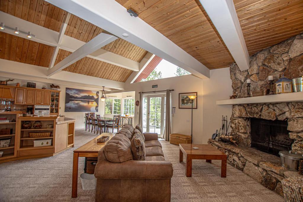 a living room with a couch and a stone fireplace at Trailside Escape By Hauserman Rentals in Tahoe City