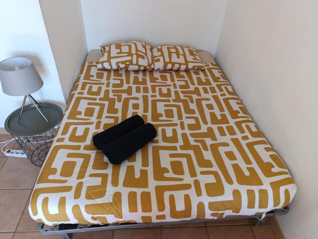 a bed with a yellow and white bedspread at Le condo douillet d'Avignon in Avignon