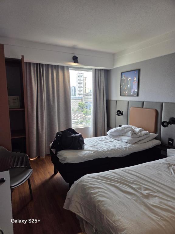a hotel room with two beds and a window at Kings Rooms in Luton