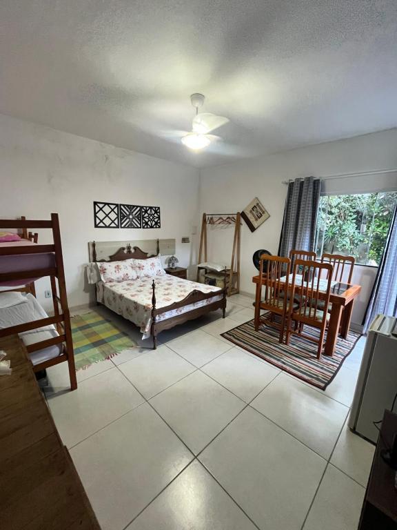 a bedroom with a bed and a table and chairs at Suíte aconchego in Cabo Frio