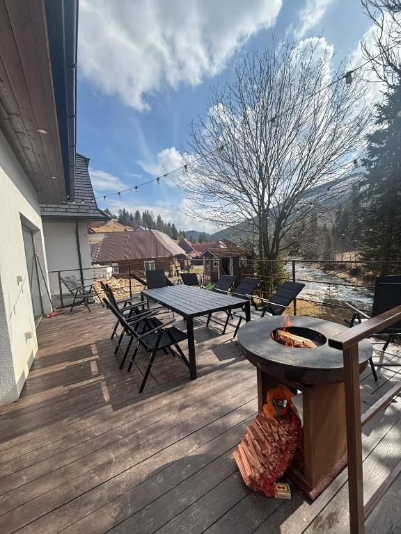 a deck with a grill and tables and chairs at Villa Tatry Zdiar in Ždiar