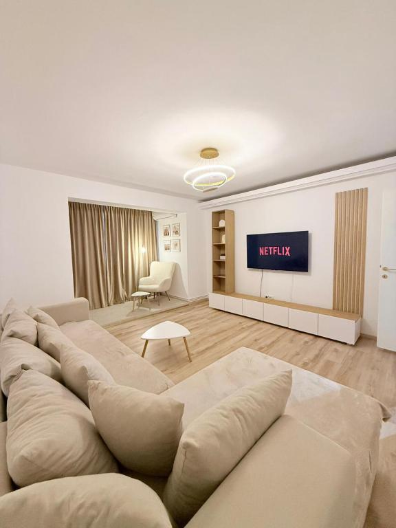 a living room with a large couch and a table at Mirajul Modern Apartment - Comfort & Style in Turda